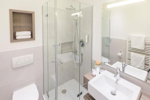 a bathroom with a glass shower and a sink at Hotel Scheffelhöhe in Bruchsal