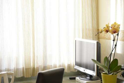 a computer monitor sitting on a desk in front of a window at Best Western Plus Soave Hotel in San Bonifacio