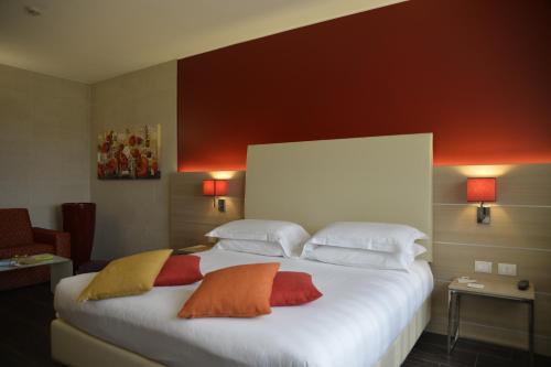 a bedroom with a large white bed with three pillows at Best Western Plus Soave Hotel in San Bonifacio