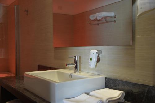a bathroom with a sink and a mirror and towels at Best Western Plus Soave Hotel in San Bonifacio
