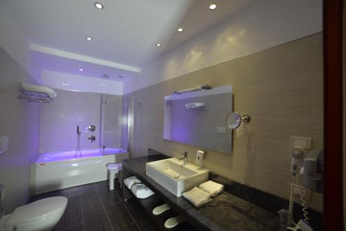 a bathroom with a sink and a toilet and a tub at Best Western Plus Soave Hotel in San Bonifacio
