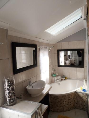 a bathroom with a tub and a sink and a bath tub at Sea View Charming Stone House in Mossel Bay
