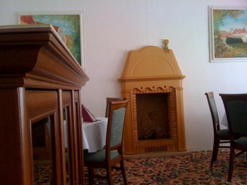 a room with a fireplace with chairs and a table at Hotel Line in Litvínov