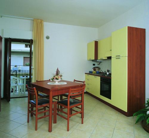 uma cozinha com uma mesa e cadeiras e um frigorífico em Residence Vittoria em Alba Adriatica