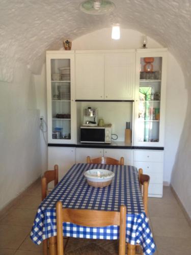 チェーリエ・メッサーピカにあるTrullo Ceglie Messapicaのキッチン(テーブル、青と白のテーブルクロス付)