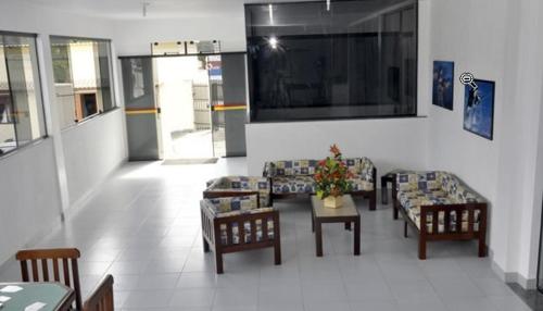 a living room with couches and tables and a television at Joalpa Hotel Cabo Frio in Cabo Frio