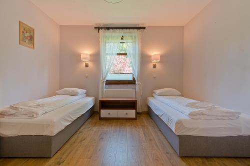 dwa łóżka w małym pokoju z oknem w obiekcie Imperial Apartments - Sopocka Przystań w mieście Sopot