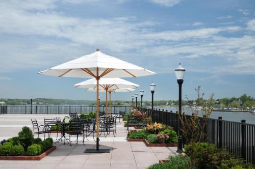 a patio with tables and chairs and white umbrellas at Molly Pitcher Inn in Red Bank