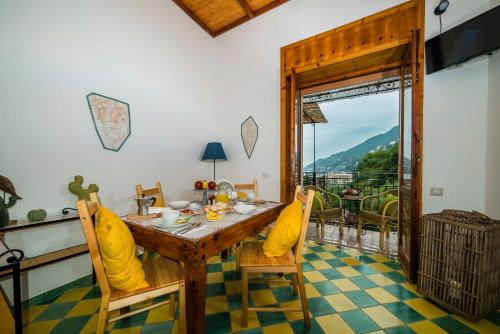 a dining room with a table and chairs and a balcony at La Valle Delle Najadi in Vietri sul Mare