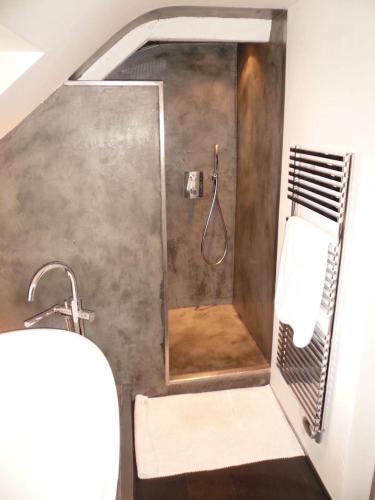 une douche avec une porte vitrée dans une salle de bain dans l'établissement La Petite Cour, à Pont-Aven