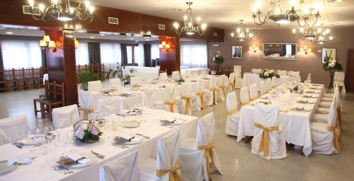 a banquet hall with white tables and white chairs at Casa Santos in Albalate de Cinca