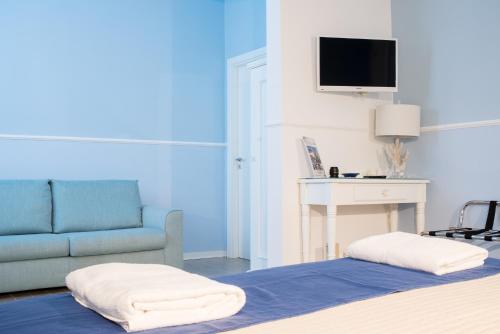 um quarto com uma cama, um sofá e uma televisão em B&B Gioia Resort em Marina di Ragusa