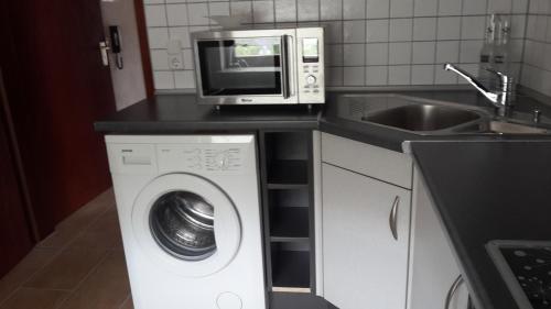 uma cozinha com um micro-ondas e uma máquina de lavar roupa em Ferienwohnung Claudia & Dino em Lahnstein