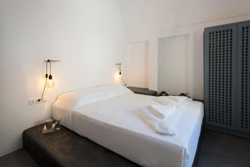 ein Schlafzimmer mit einem weißen Bett mit zwei Handtüchern darauf in der Unterkunft Onirondas Villas in Fira