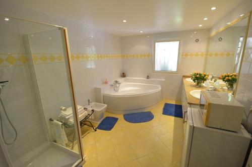 La salle de bains est pourvue d'une baignoire, de toilettes et d'une douche. dans l'établissement Au vallon rouge (Suite double), à Saint-Paul-de-Vence
