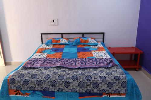a bedroom with a bed with a quilt on it at Athaang Beach Resort in Malvan