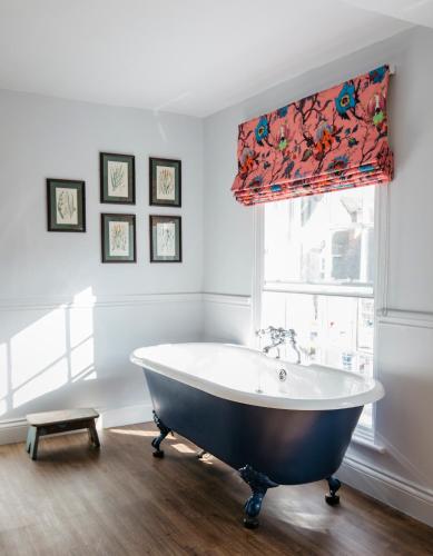 a bath tub in a bathroom with a window at The Bower House, Restaurant & Rooms in Shipston on Stour