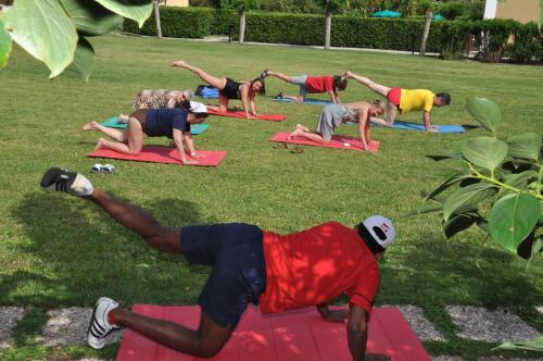 a group of people doing yoga in the grass at Residence Le Acacie in Capoliveri