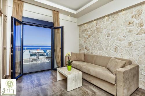 a living room with a couch and a stone wall at Frini Studios in Plomarion