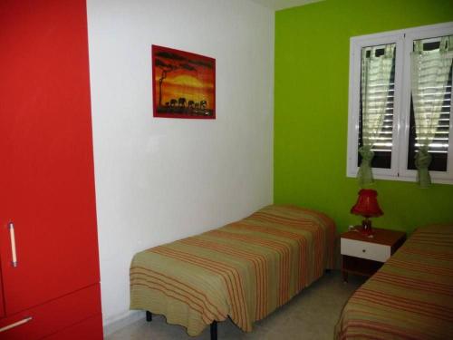 トッレ・デル・オルソにあるAppartamento12 Sol&Marの緑と白の壁のベッドルーム1室、ベッド2台が備わります。
