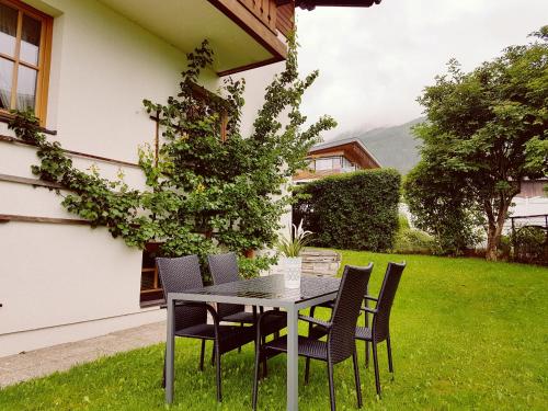 a table and chairs in the yard of a house at Chalet SONNECK Summer Card included in Kaprun