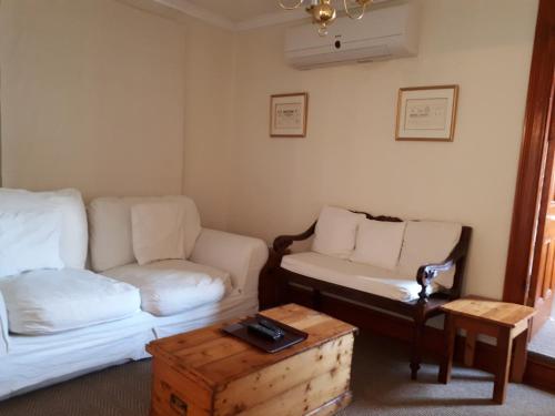 a living room with a couch and a table at De Kothuize 10 in Graaff-Reinet