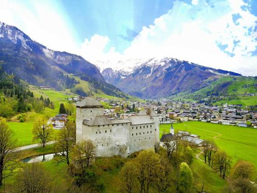 an old building on a hill with mountains in the background at Chalet SONNECK Summer Card included in Kaprun