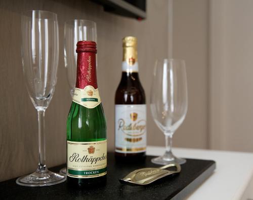 zwei Flaschen Wein und zwei Gläser auf dem Tisch. in der Unterkunft Haus am See Rossbach in Roßbach