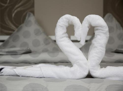 einen Haufen weißer Handtücher auf einem Bett in der Unterkunft Haus am See Rossbach in Roßbach
