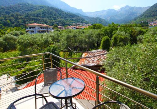 a table and chairs on a balcony with a view of mountains at Asteras Kalives in Skala Potamias