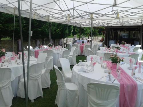 a group of tables with white chairs and white tablesearcher at Naiades Guesthouse in Klávsion