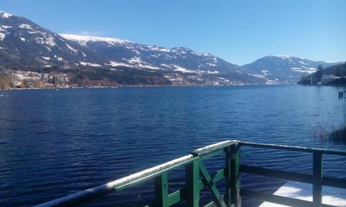 a view of a lake with snow covered mountains at Smileys Seehäuschen in Seeboden