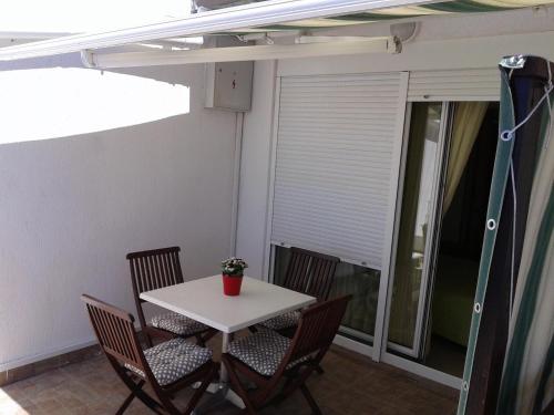 a small table and chairs on a balcony with a window at Apartments Toma Bajnice Directly in Krilo
