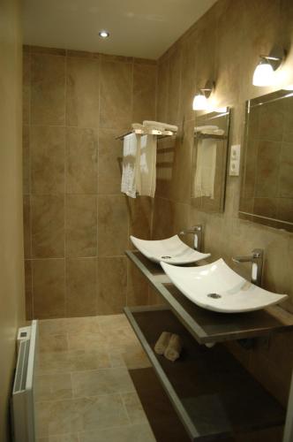 een badkamer met 2 wastafels en een grote spiegel bij Beaune Residence appartement in Beaune