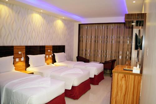 a hotel room with four beds and a desk at Zagy Hotel in Dubai