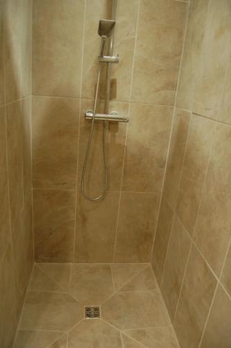a shower with a hose in a bathroom at Beaune Residence appartement in Beaune