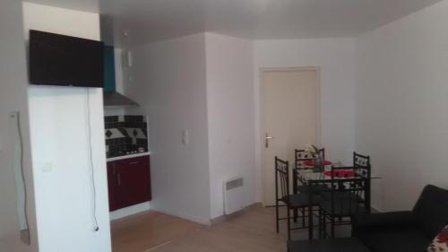 a living room with a kitchen and a table with chairs at Appartements Sully in Mantes-la-Jolie