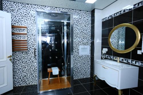 a bathroom with a shower and a sink and a mirror at Spring Hotel in Novxanı
