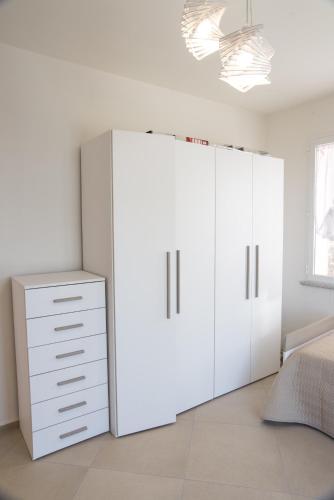 a bedroom with white cabinets and a white dresser at Villa Il Roseto Redinoce in Procchio