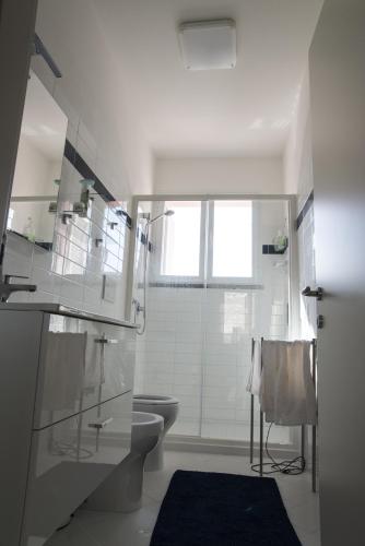 a white bathroom with a toilet and a shower at Villa Il Roseto Redinoce in Procchio