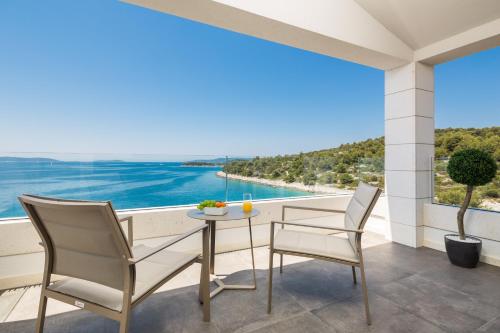 a balcony with a table and chairs and a view of the ocean at Villa Argemonia in Trogir