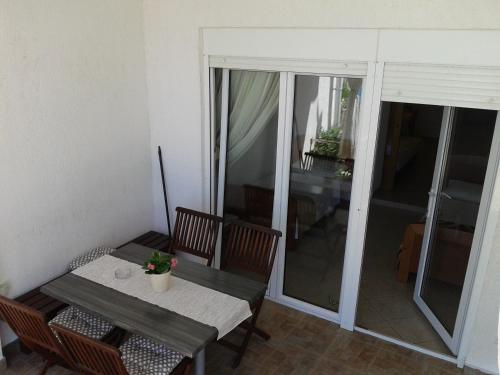 a table and chairs in a room with a table and glass doors at Apartments Toma Bajnice Directly in Krilo