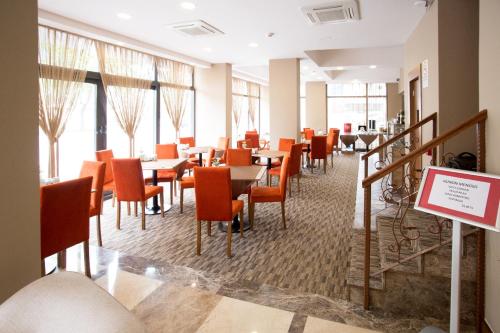 a dining room with tables and chairs and windows at Otel Vona in Ordu