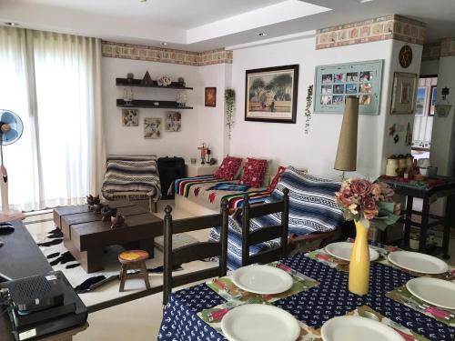 a living room with a couch and a table at Mexican Beachfront Condo in Khao Tao