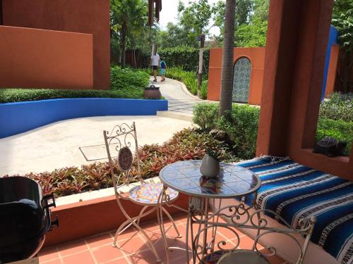 a patio with a table and chairs and a sidewalk at Mexican Beachfront Condo in Khao Tao