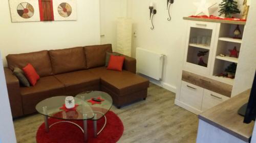 a living room with a couch and a glass table at Haus Isabelle EG in Sankt Andreasberg