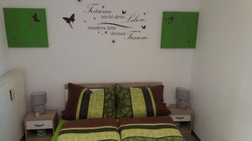 a bedroom with a bed with two night stands and signs on the wall at Haus Isabelle EG in Sankt Andreasberg