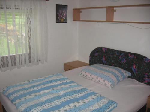 a bedroom with a bed with a blanket on it at Penzión Závada in Nová Lesná