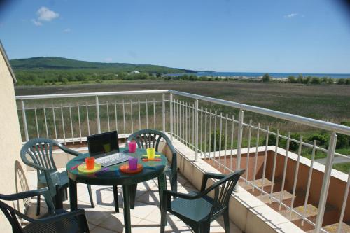 een balkon met een tafel en een laptop. bij Pearl Sunshine Appartments in Primorsko