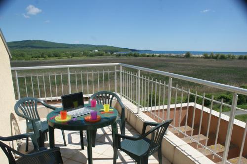 a balcony with a table with a laptop on it at Pearl Sunshine Appartments in Primorsko